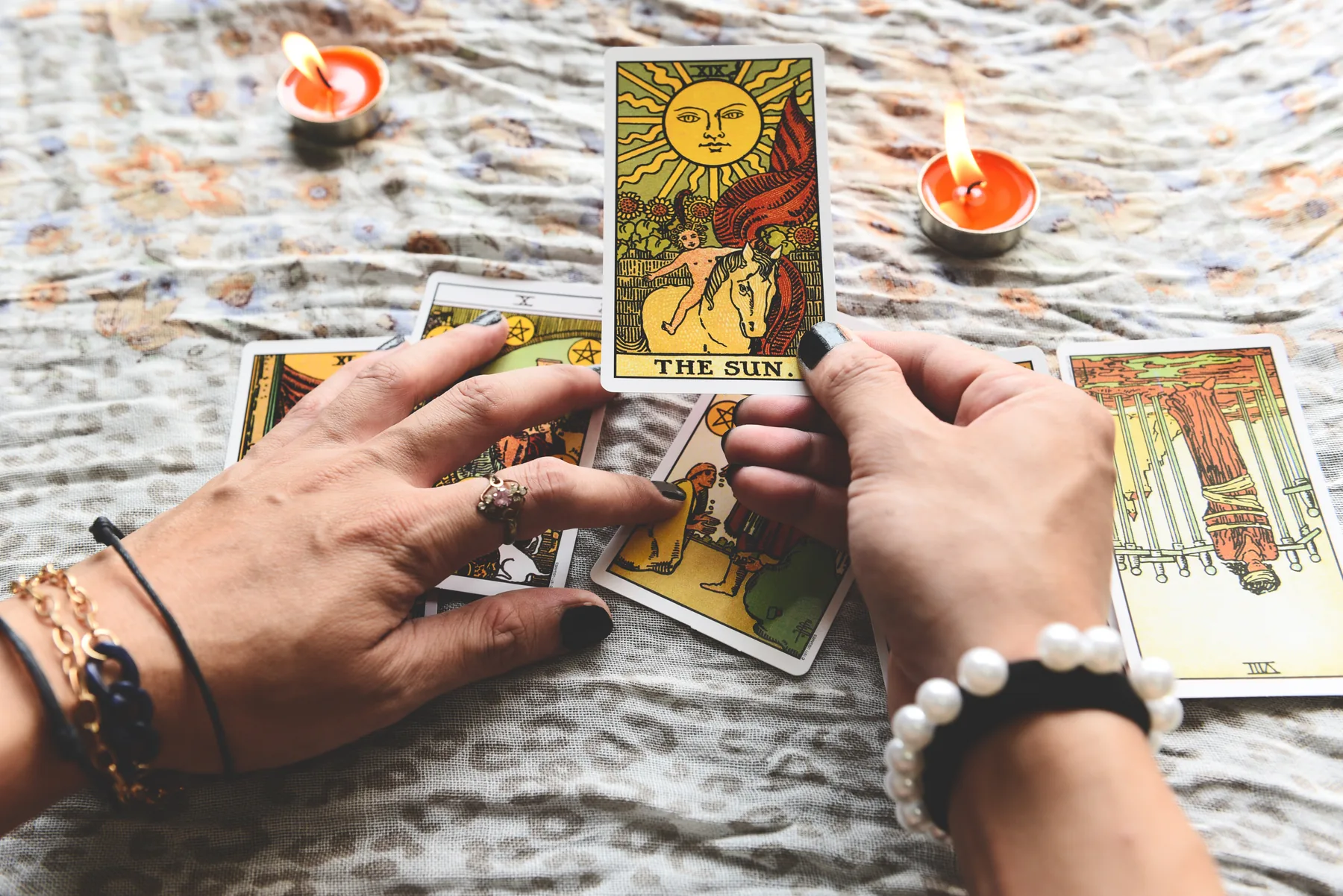 Manos de tarotista sosteniendo cartas durante una lectura